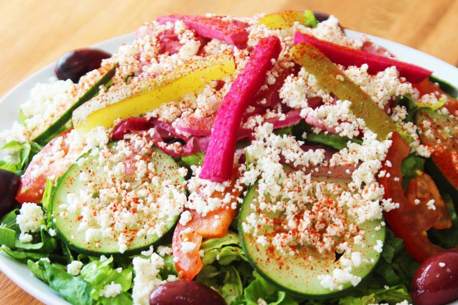 Fresh salad with colorful vegetables and crumbled cheese.