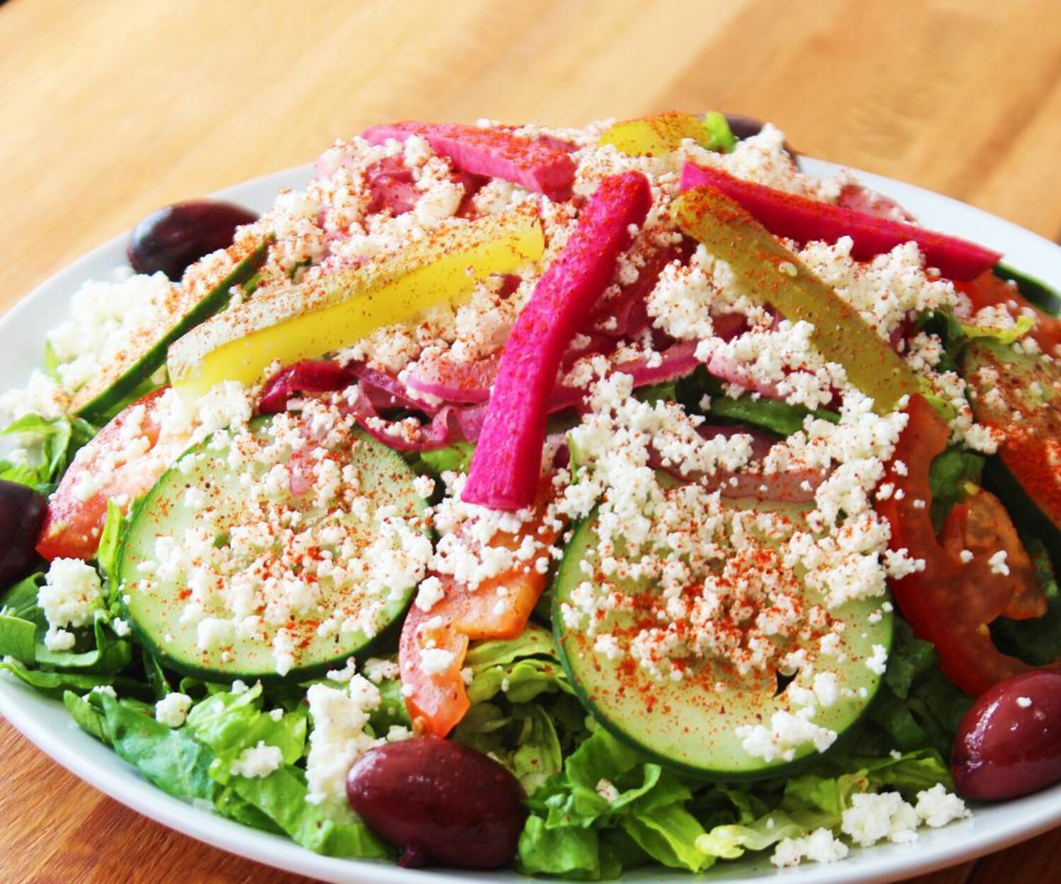 Fresh salad with colorful vegetables and crumbled cheese.