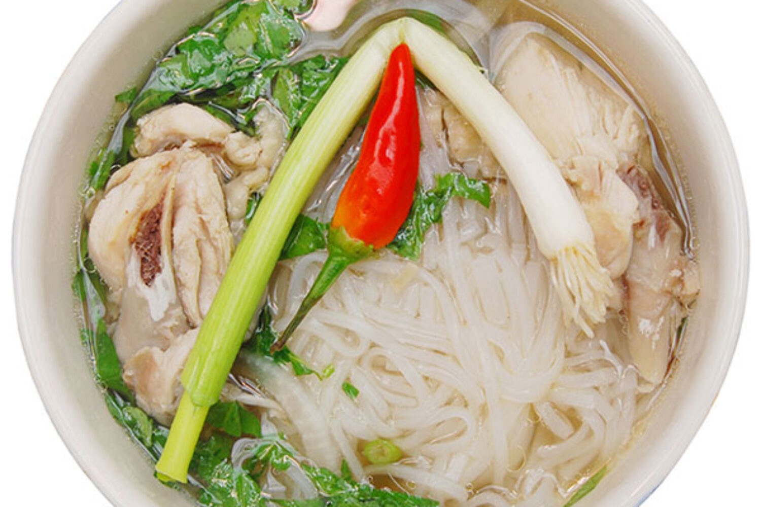 A bowl of Asian noodle soup with vegetables and chili.