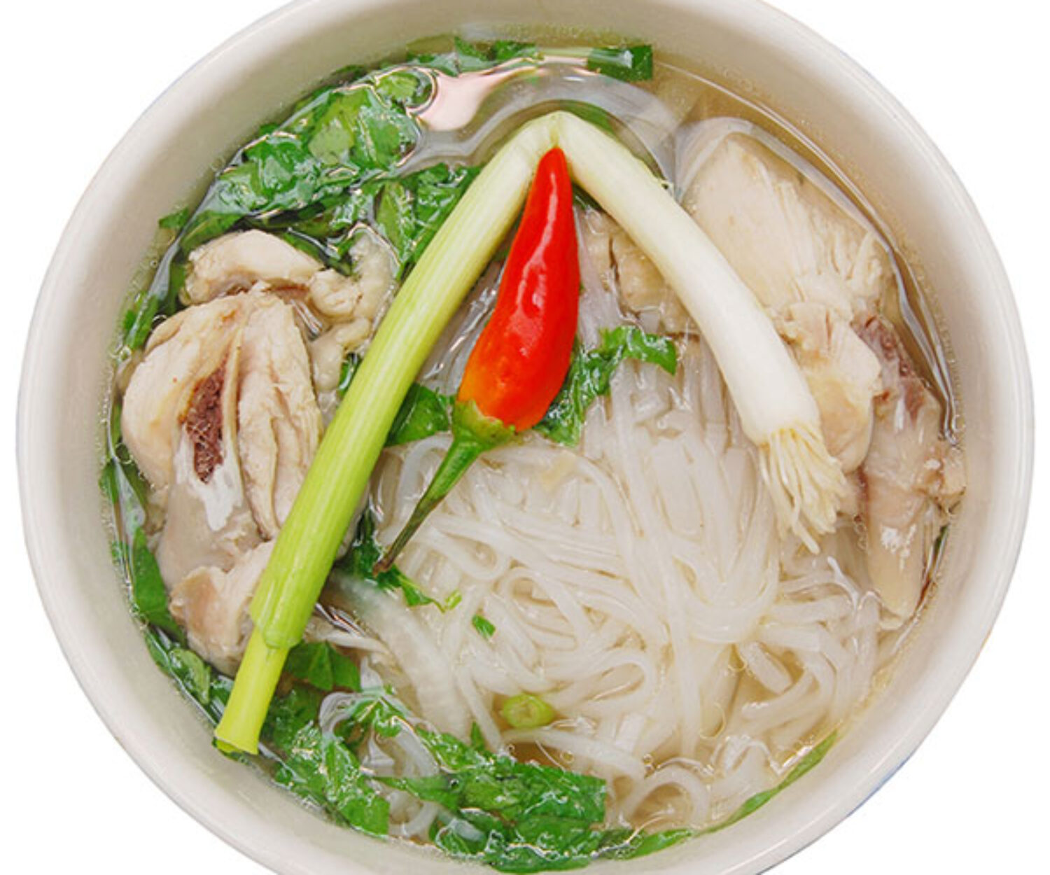 A bowl of Asian noodle soup with vegetables and chili.