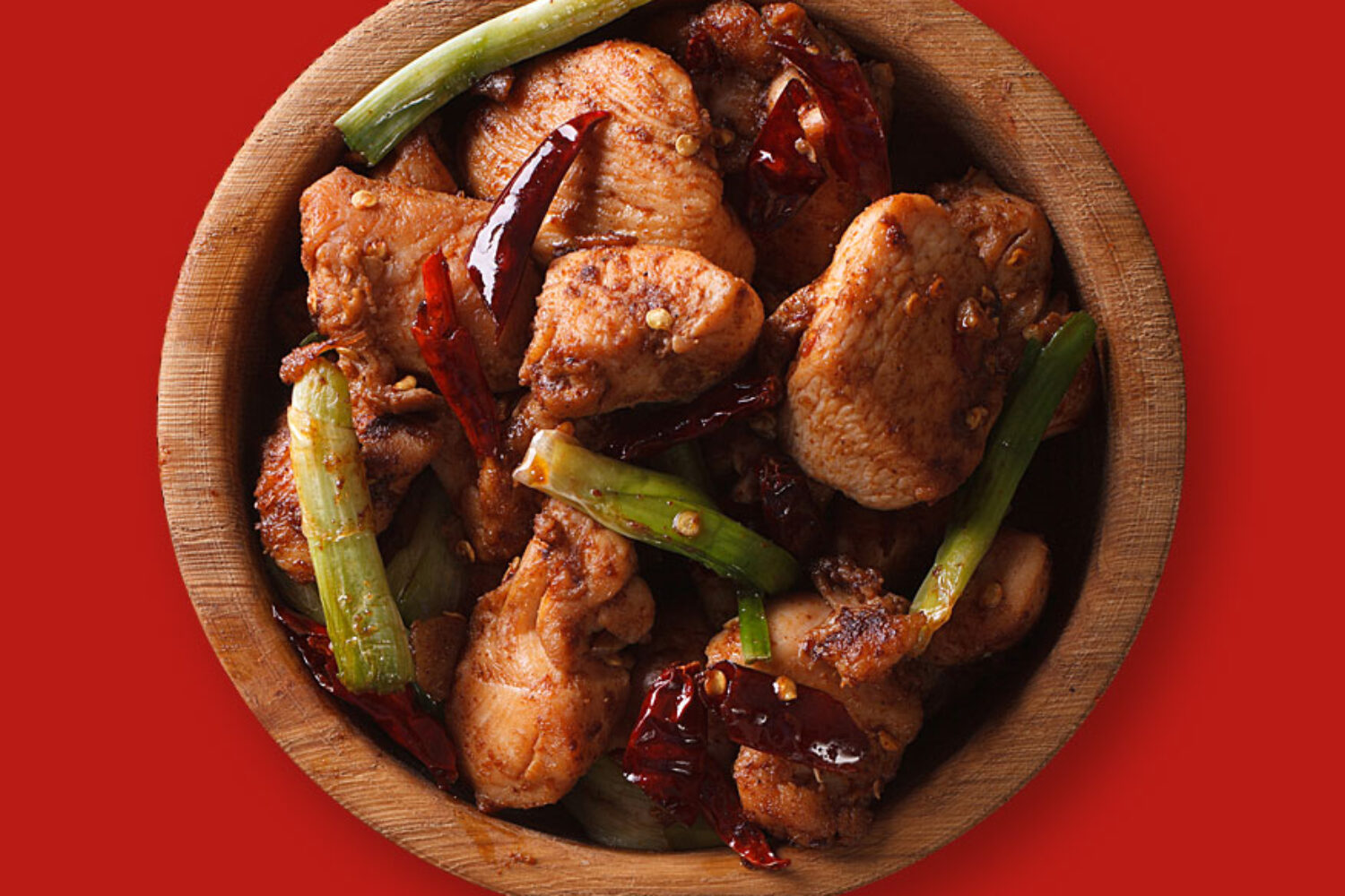 Grilled chicken wings with green beans on a wooden plate.