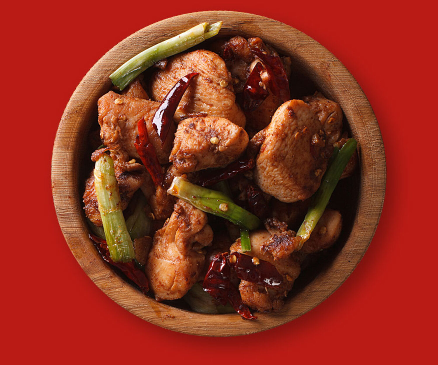 Grilled chicken wings with green beans on a wooden plate.